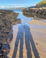 J & M shadows across the beach at Aberporth